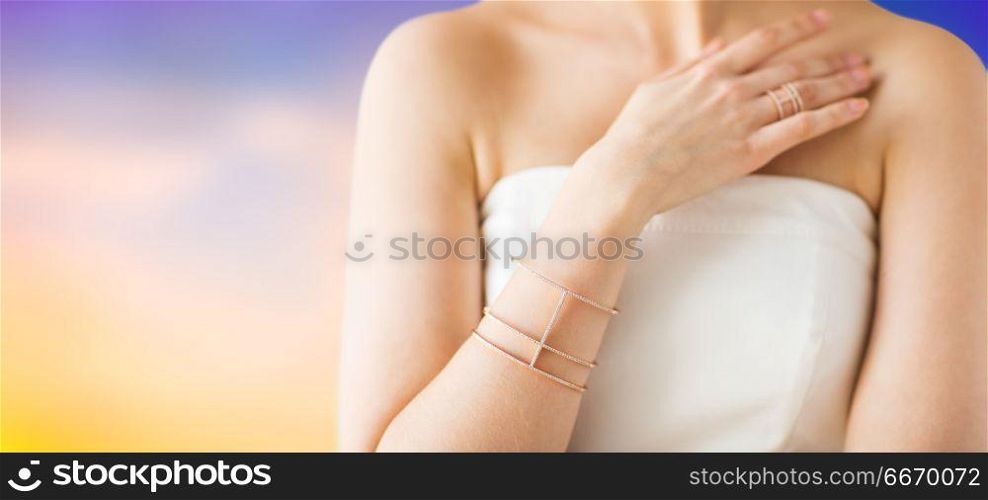 beauty, jewelry and luxury concept - close up of beautiful woman with golden ring and bracelet over pastel background. close up of beautiful woman with ring and bracelet. close up of beautiful woman with ring and bracelet