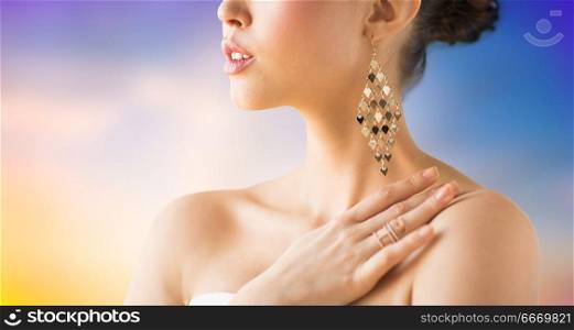 beauty, jewelry and luxury concept - close up of beautiful woman with earrings over pastel background. close up of beautiful woman with earrings. close up of beautiful woman with earrings