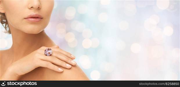 beauty, jewelry, people and accessories concept - close up of woman with cocktail ring on hand over blue holidays lights background