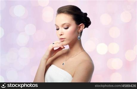 beauty, jewelry, people and luxury concept - beautiful asian woman or bride with earring, finger ring and pendant over rose quartz and serenity lights background