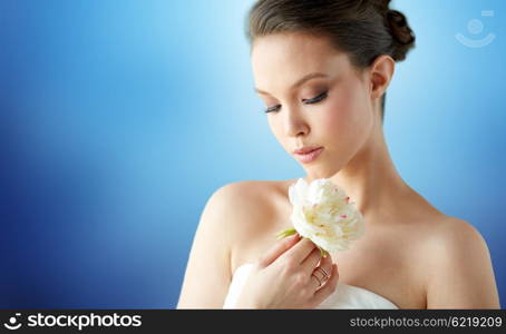 beauty, jewelry, people and luxury concept - beautiful asian woman or bride in white dress with peony flowe and golden ring over blue background