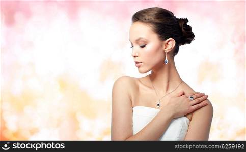 beauty, jewelry, people and luxury concept - beautiful asian woman or bride with earring, finger ring and pendant over holidays lights background