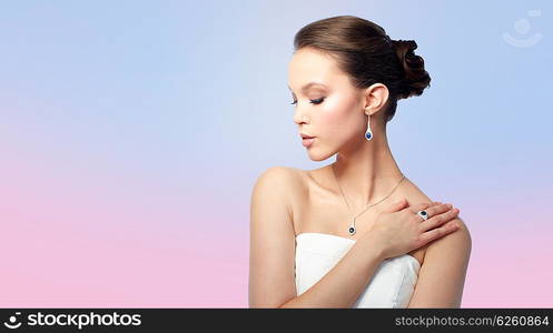 beauty, jewelry, people and luxury concept - beautiful asian woman or bride with earring, finger ring and pendant over rose quartz and serenity gradient background