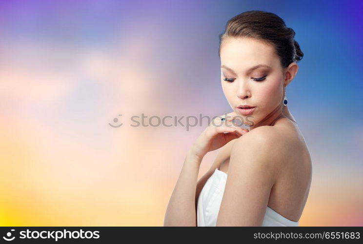 beauty, jewelry, people and luxury concept - beautiful asian woman or bride with earring and finger ring over pastel background. beautiful woman with earring and finger ring. beautiful woman with earring and finger ring