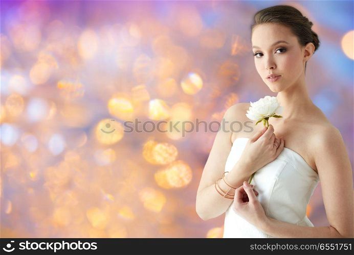 beauty, jewelry, people and luxury concept - beautiful asian woman or bride in white dress with peony flower, golden ring and bracelet over holidays lights background. beautiful asian woman with flower and jewelry. beautiful asian woman with flower and jewelry
