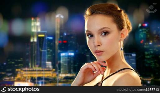 beauty, jewelry, people and luxury concept - beautiful asian woman with diamond earring over singapore city night lights background