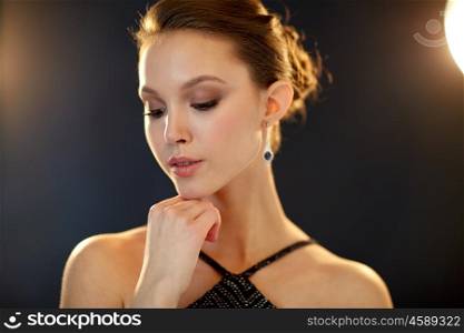 beauty, jewelry, people and luxury concept - beautiful asian woman with diamond earring over black background