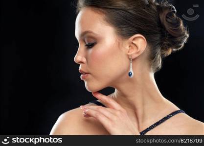 beauty, jewelry, people and luxury concept - close up of beautiful young asian woman with earring over black background