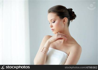 beauty, jewelry, wedding accessories, people and luxury concept - beautiful asian woman or bride with golden ring and bracelet