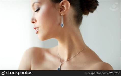 beauty, jewelry, wedding accessories, people and luxury concept - beautiful asian woman or bride with earring and pendant