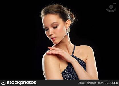 beauty, jewelry, wedding accessories, people and luxury concept - beautiful asian woman with diamond earring over black background