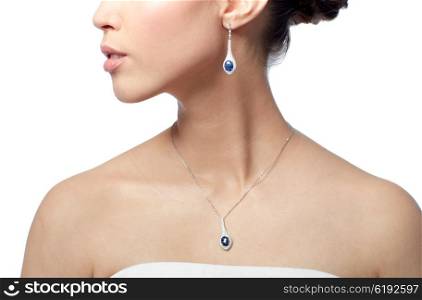 beauty, jewelry, wedding accessories, people and luxury concept - close up of beautiful asian woman or bride with earring and pendant