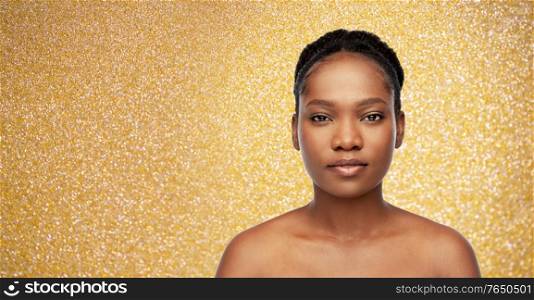 beauty, luxury and people concept - portrait of young african american woman with bare shoulders over golden glitter on background. portrait of young african american woman