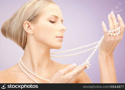 beauty, luxury, people, advertisement and jewelry concept - beautiful woman with sea pearl necklace or beads in hand over violet background