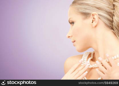 beauty, luxury, people, advertisement and jewelry concept - beautiful woman with sea pearl necklace or beads over violet background