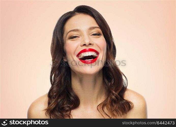beauty, make up and people concept - happy laughing young woman with red lipstick over beige background. beautiful laughing young woman with red lipstick