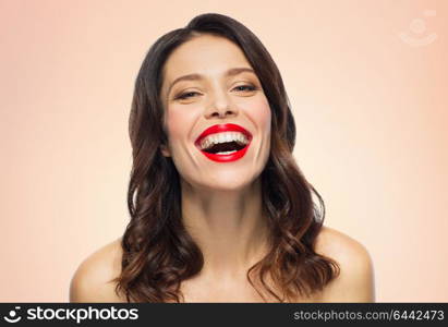 beauty, make up and people concept - happy laughing young woman with red lipstick over beige background. beautiful laughing young woman with red lipstick