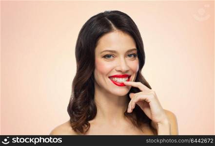 beauty, make up and people concept - happy smiling young woman with red lipstick posing over beige background. beautiful smiling young woman with red lipstick