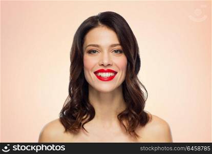 beauty, make up and people concept - happy smiling young woman with red lipstick over beige background. beautiful smiling young woman with red lipstick