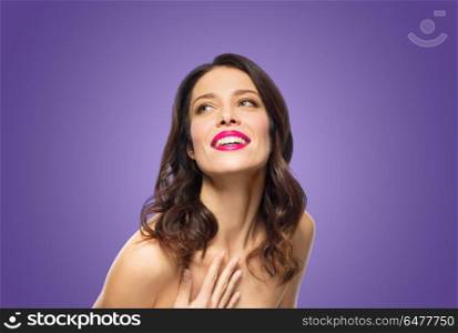 beauty, make up and people concept - happy smiling young woman with pink lipstick posing over ultra violet background. beautiful smiling young woman with pink lipstick. beautiful smiling young woman with pink lipstick