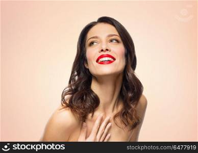 beauty, make up and people concept - happy smiling young woman with red lipstick posing over beige background. beautiful smiling young woman with red lipstick. beautiful smiling young woman with red lipstick