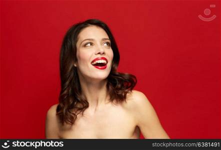 beauty, make up and people concept - happy smiling young woman with red lipstick looking up. beautiful smiling young woman with red lipstick