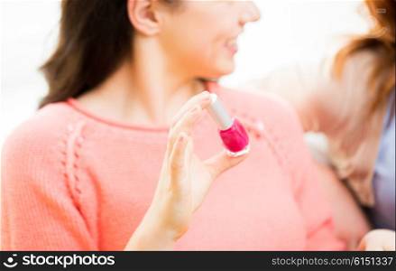 beauty, make up, cosmetics and people concept - close up of smiling young woman with pink nail polish