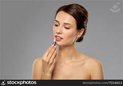 beauty, makeup and cosmetics concept - happy smiling young woman with pink lipstick over white background. beautiful smiling young woman with pink lipstick