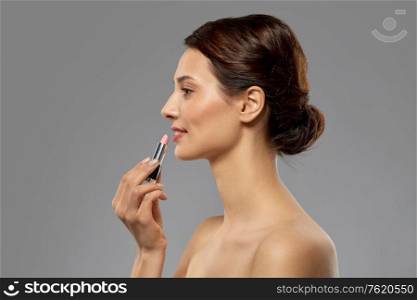 beauty, makeup and cosmetics concept - happy smiling young woman with pink lipstick over white background. beautiful smiling young woman with pink lipstick