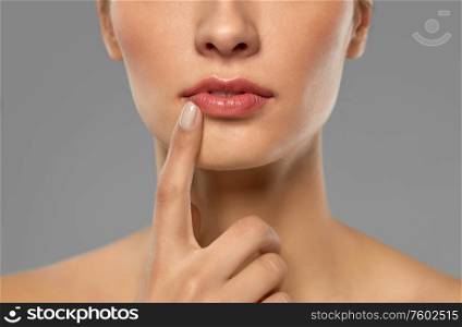 beauty, makeup and people concept - close up of beautiful young woman face and lips over grey background. close up of beautiful young woman face and lips