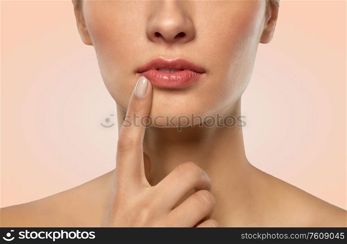 beauty, makeup and people concept - close up of beautiful young woman face and lips over beige background. close up of beautiful young woman face and lips