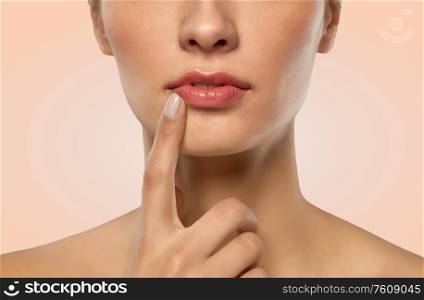 beauty, makeup and people concept - close up of beautiful young woman face and lips over beige background. close up of beautiful young woman face and lips