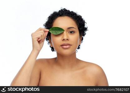 beauty, nature and people concept - portrait of young african american woman with green leaf over white background. portrait of african american woman with green leaf