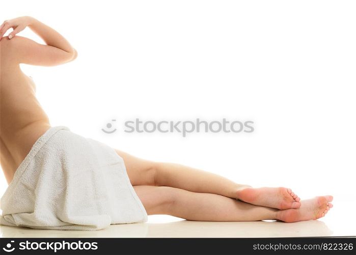 Beauty of body care, showering, clean and fresh skin concept. Naked woman in towel sitting on floor after bathing. Studio shot isolated. Sitting naked woman in white towel