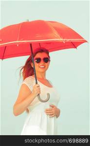 Beauty of ginger hair concept. Portrait of beautiful happy redhead adult plus size woman holding red umbrella wearing sunglasses in heart shape.. Portrait of redhead adult woman holding umbrella