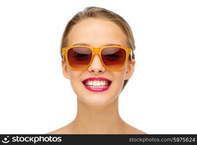beauty, people, accessory and fashion concept - smiling young woman in sunglasses with pink lipstick on lips