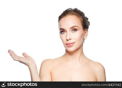 beauty, people, advertisement and health concept - smiling young woman holding something on palm of her hand