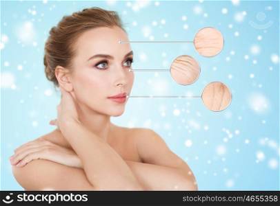 beauty, people, aging and skin care concept - beautiful young woman and circles with magnified facial wrinkles over blue background and snow