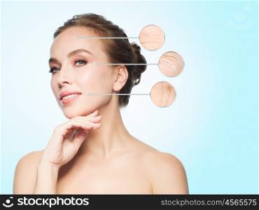 beauty, people, aging and skin concept - beautiful young woman touching her face over blue background