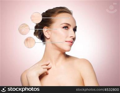 beauty, people and aging concept - beautiful young woman touching her face over beige background