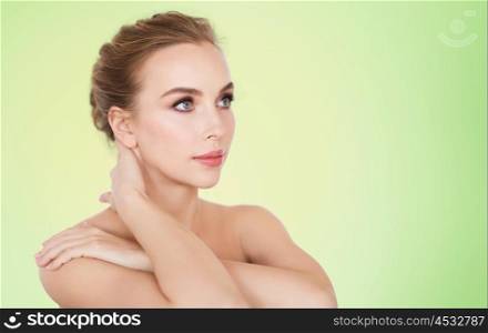 beauty, people and body care concept -beautiful young woman face and hands over green background