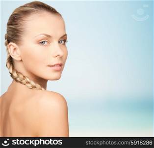 beauty, people and body care concept - beautiful young woman with bare shoulders over blue background