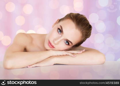 beauty, people and bodycare concept -beautiful young woman face and hands over rose quartz and serenity lights background