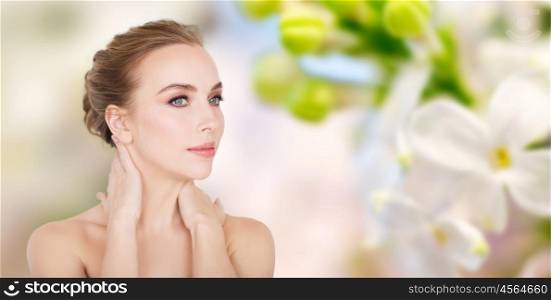 beauty, people and bodycare concept -beautiful young woman face and hands over natural lilac blossom background