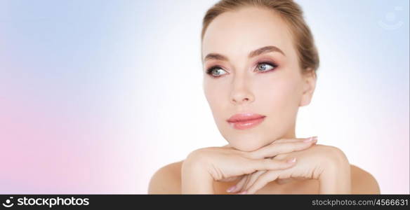 beauty, people and bodycare concept -beautiful young woman face and hands over rose quartz and serenity gradient background