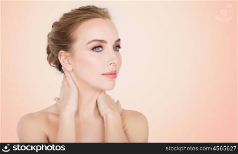 beauty, people and bodycare concept -beautiful young woman face and hands over beige background