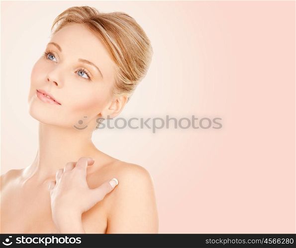 beauty, people and bodycare concept - beautiful young woman face and hands over beige background