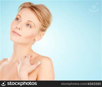 beauty, people and bodycare concept - beautiful young woman face and hands over blue background