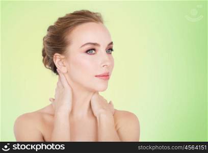 beauty, people and bodycare concept -beautiful young woman face and hands over green natural background