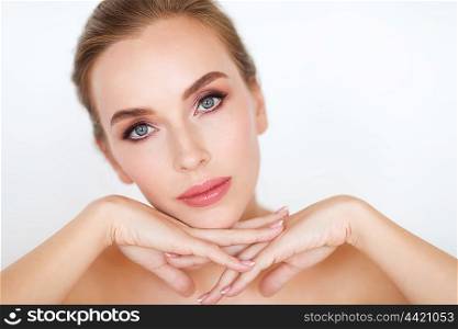 beauty, people and bodycare concept -beautiful young woman face and hands over white background